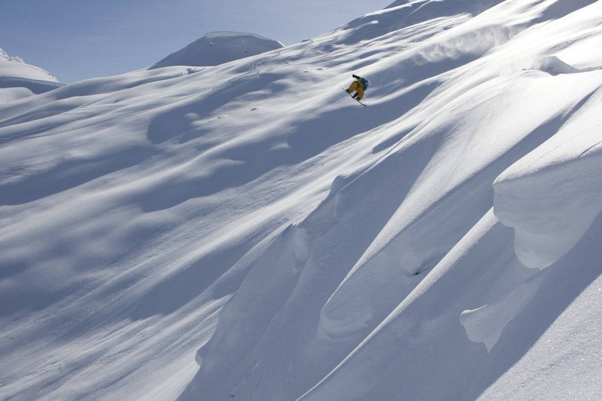Professional snowboarder, Frederik Kalbermatten, heli boarding in the mountains above Haines - Powderaddicts