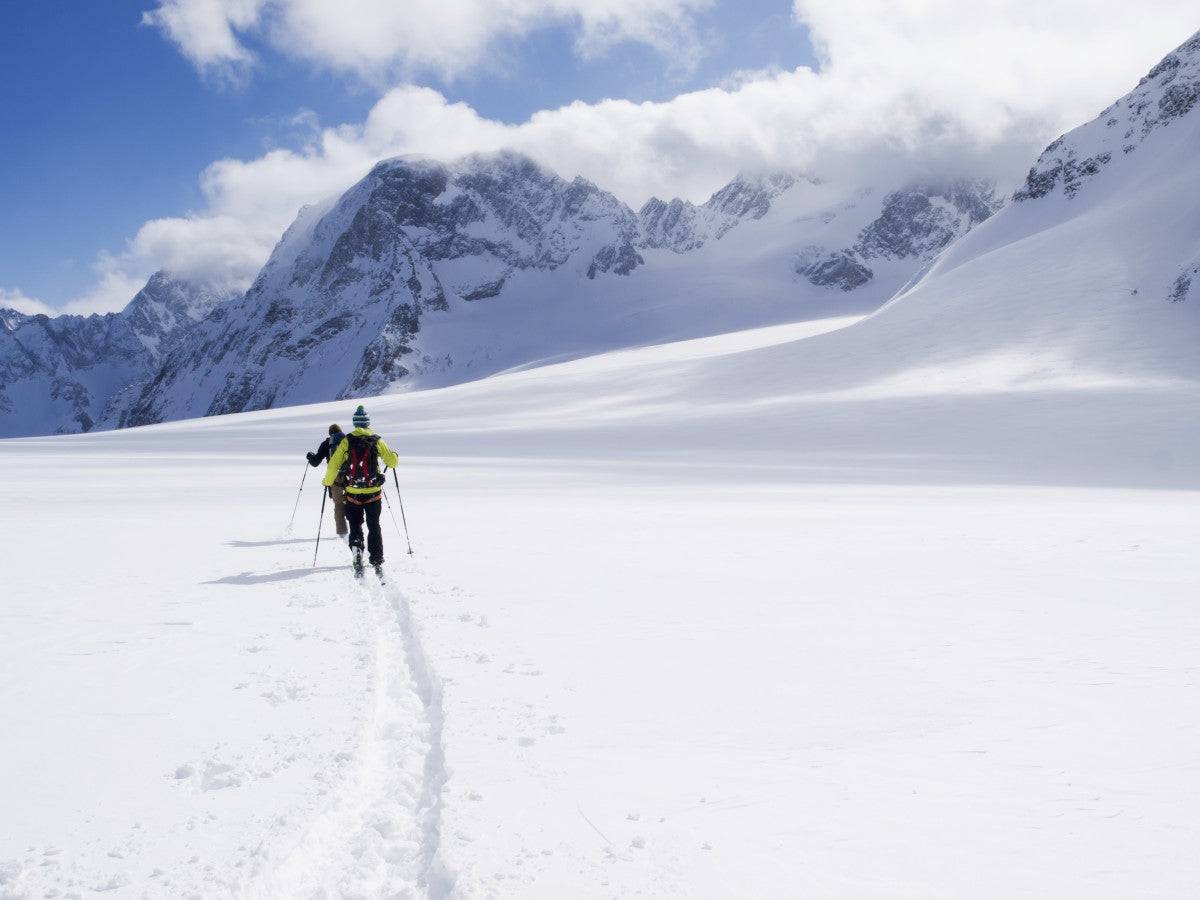 Two skiers ski touring across the Ottemma glacier - Powderaddicts