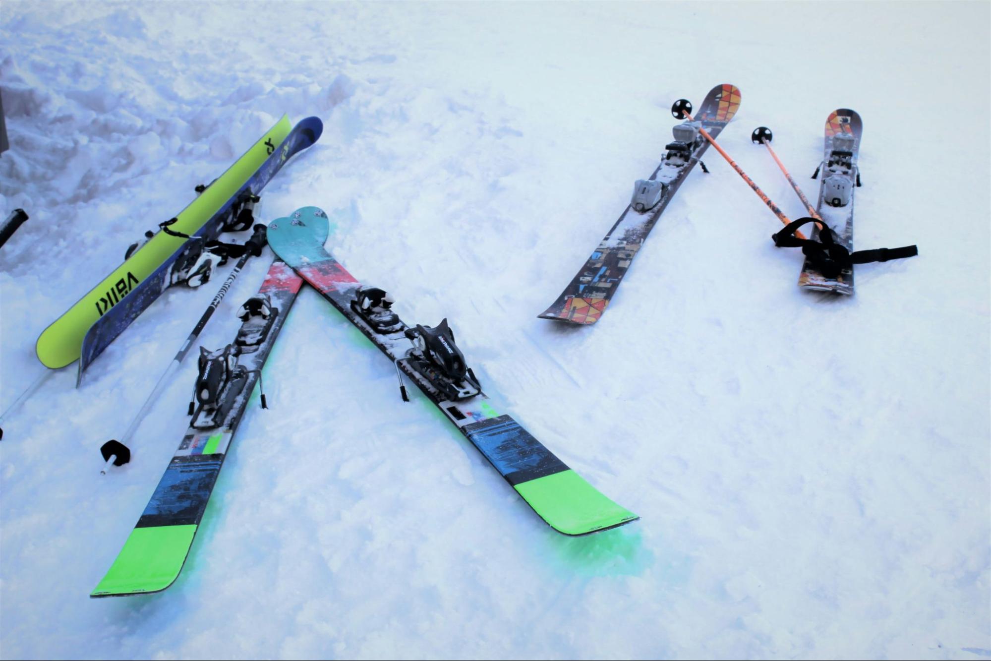 Three sets of skis and poles in the snow