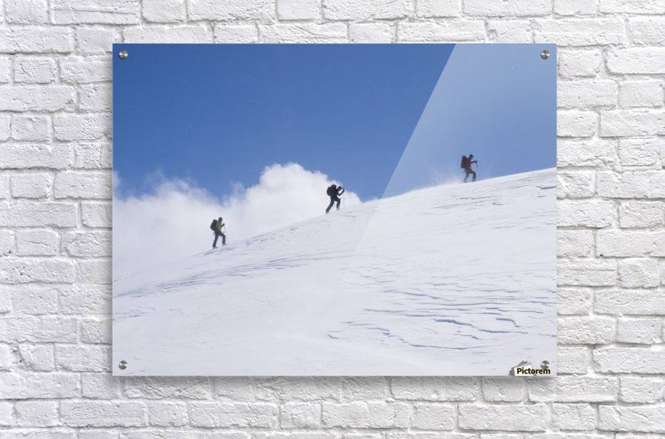 Three ski tourists walking to the summit - Powderaddicts
