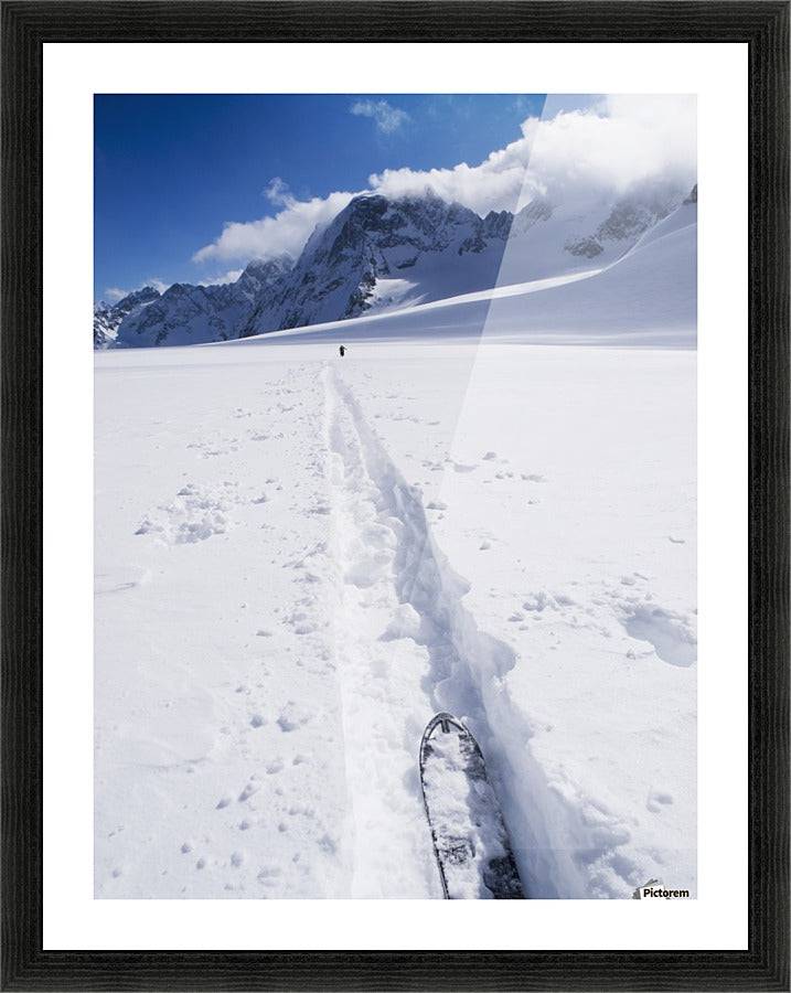 Two distant skiers ski touring across the Ottemma glacier, with skinning tracks - Powderaddicts