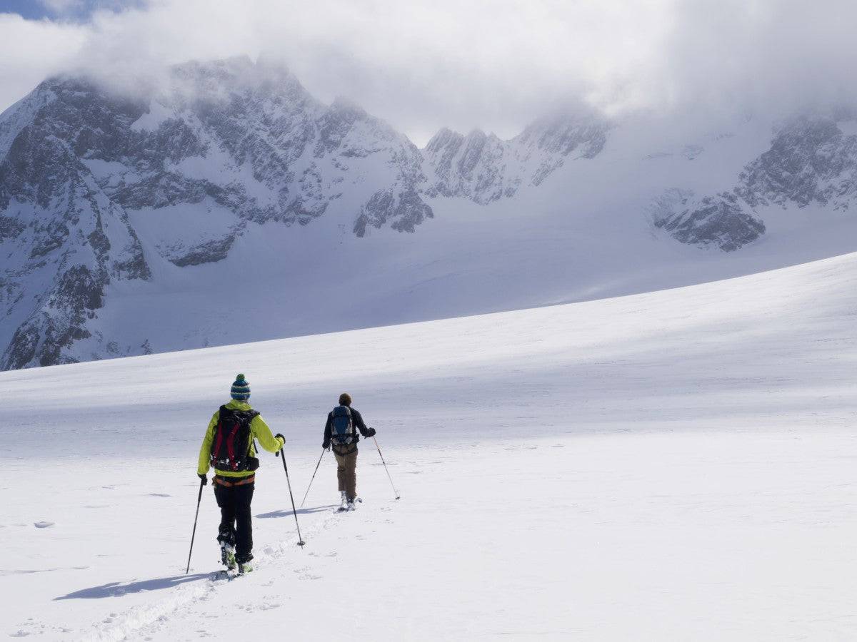 Two skiers ski touring across the Ottemma glacier - Powderaddicts
